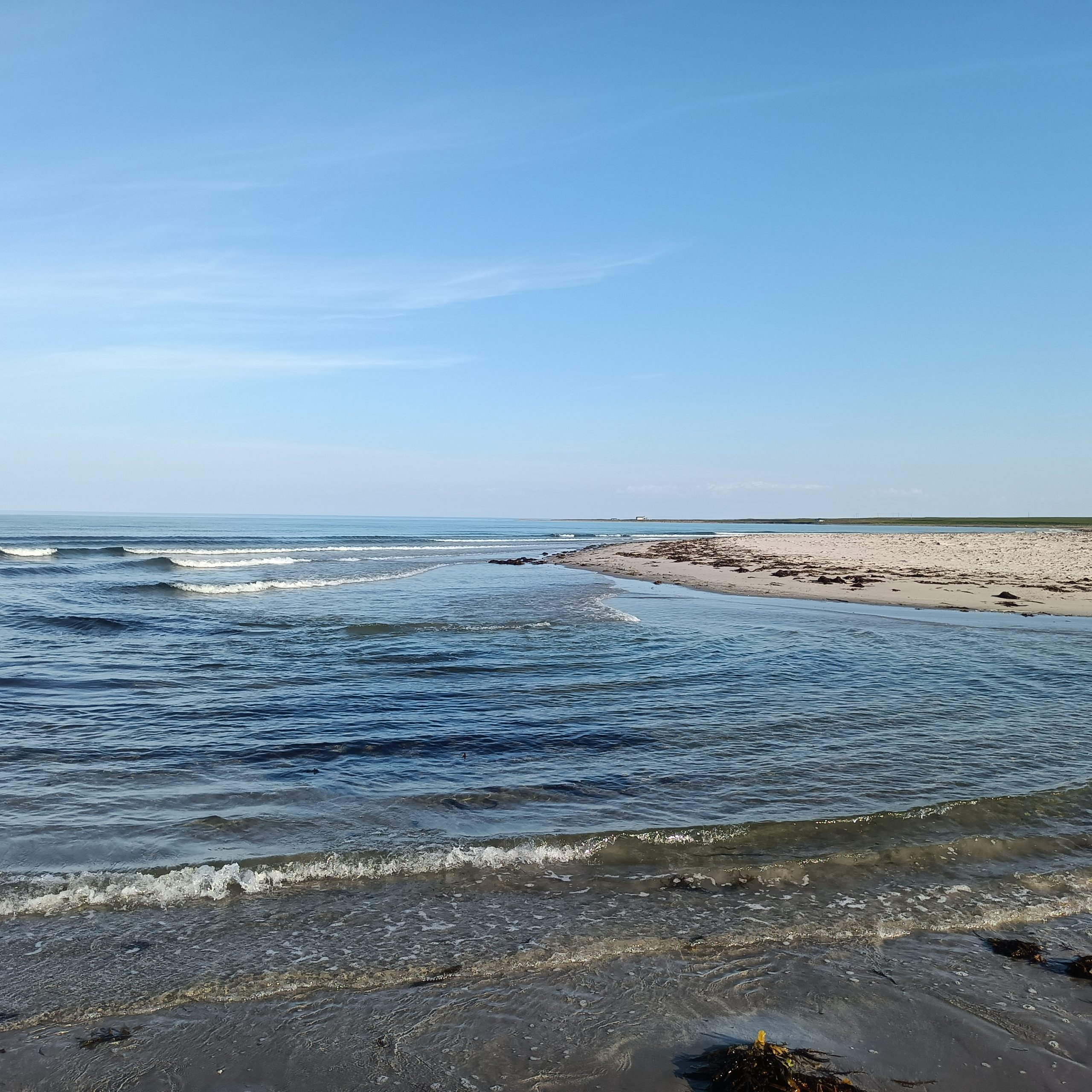 Kiesstrand und dahinter das Meer. Rechts ist Sandstrand.