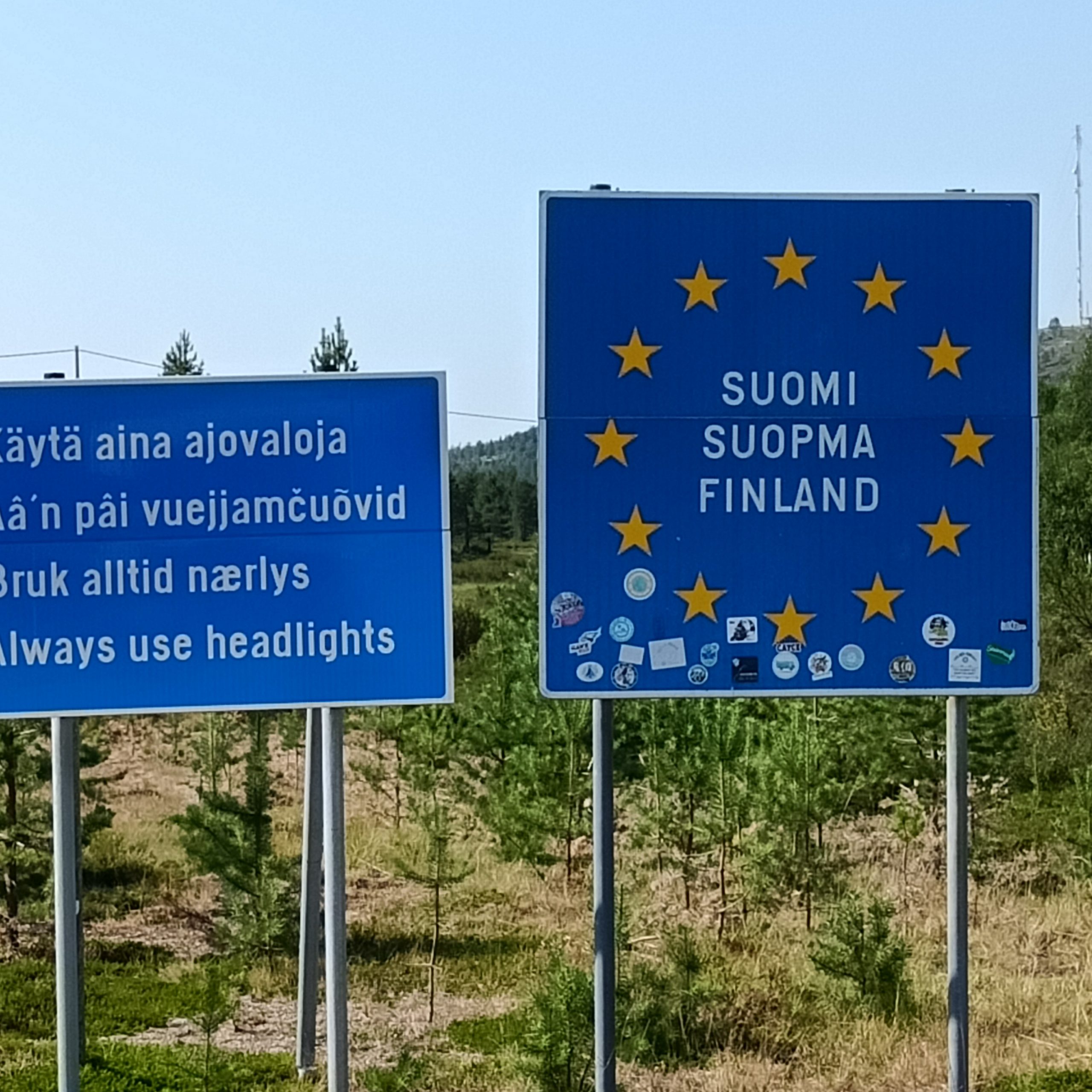 Zwei blaue Schilder. Landesgrenze Finnland Tschüss Norwegen - Hallo Finnland