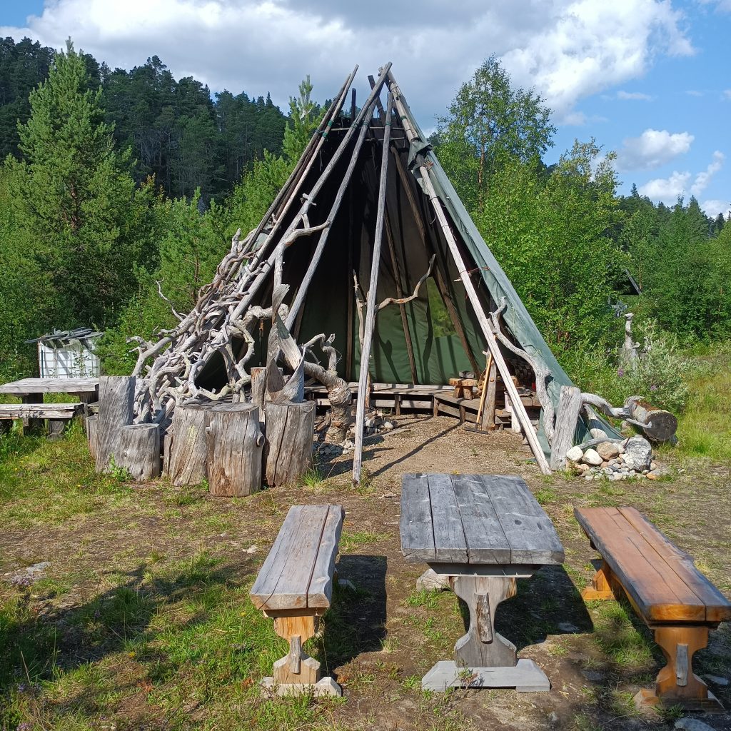Tisch und Sitzbänke vor einem Grillzelt