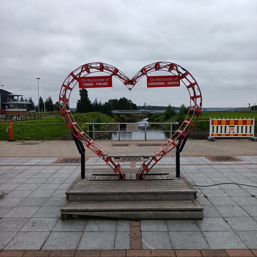 Rotes Herz mit Bank an der Grenze 