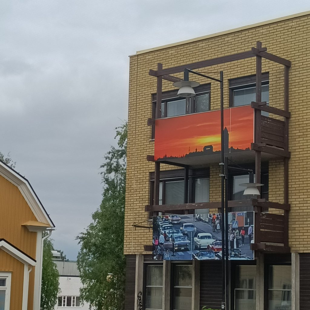 Gelbes Backsteinhaus mit Bilder an den Balkonen