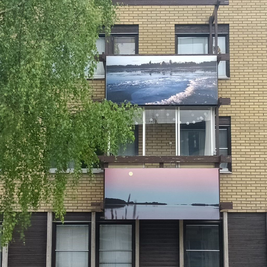 Gelbes Backsteinhaus mit Bilder an den Balkonen