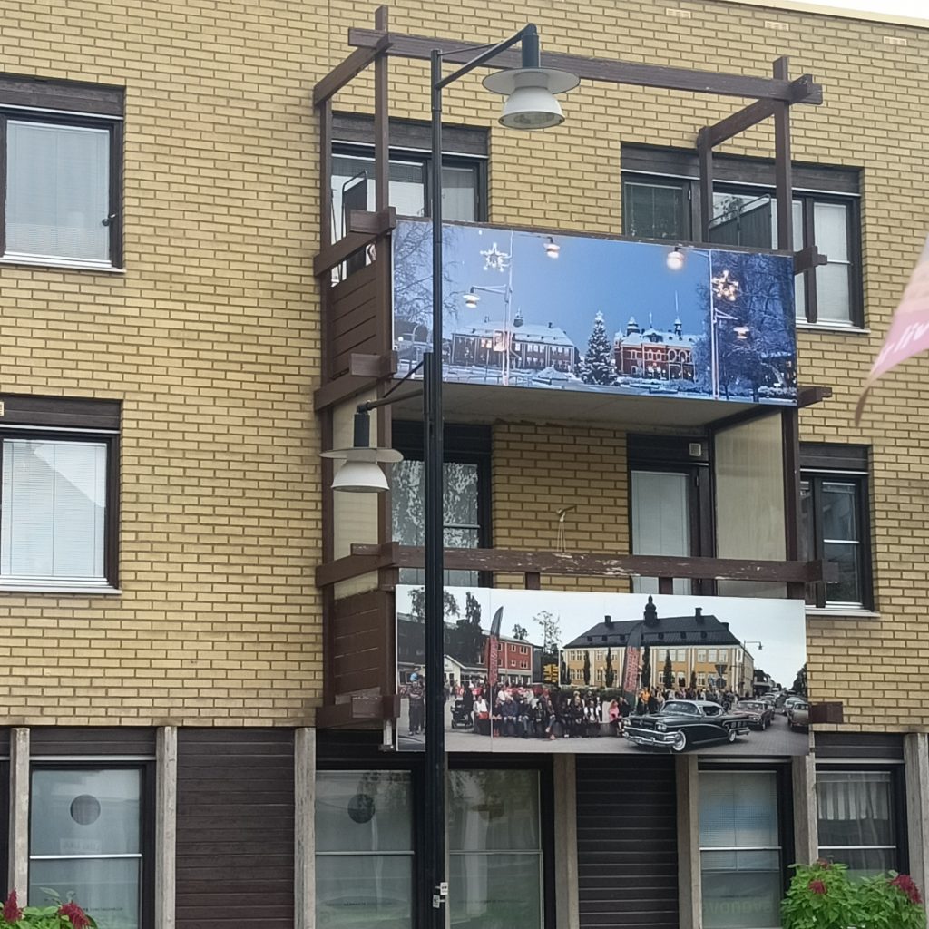 Gelbes Backsteinhaus mit Bilder an den Balkonen