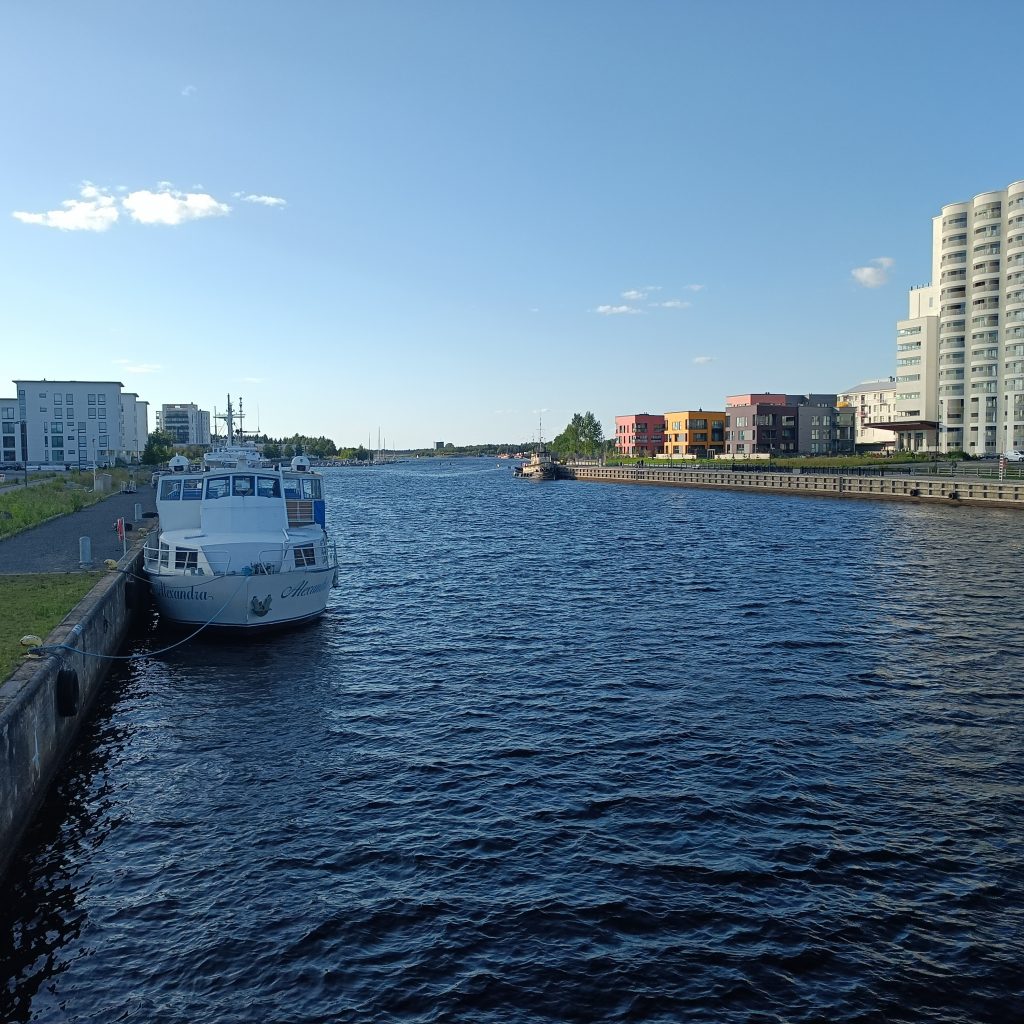 Kanal mit Boot links und Hochhaus rechts