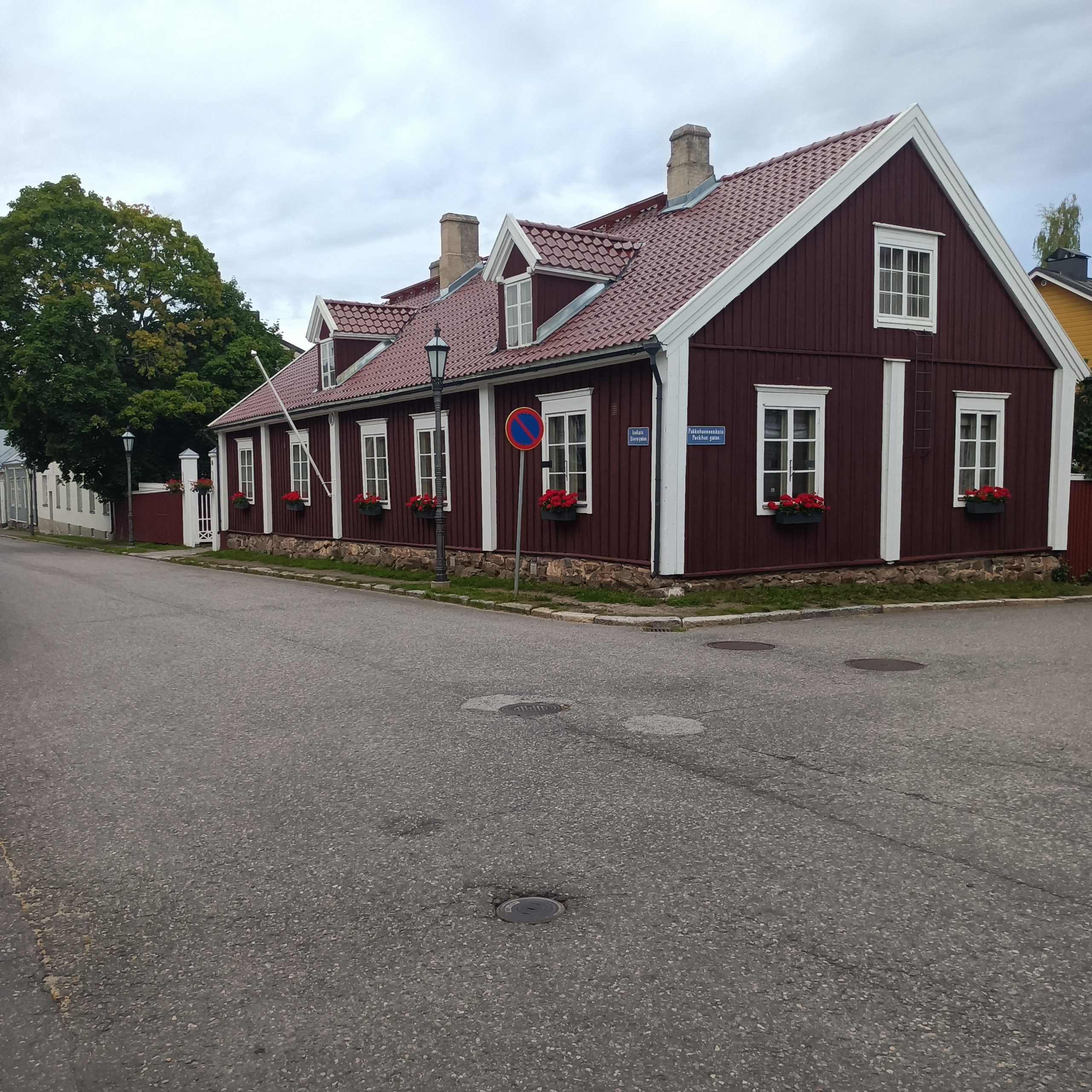 Gehweg und Straße vor roten Haus mit weißen Kanten