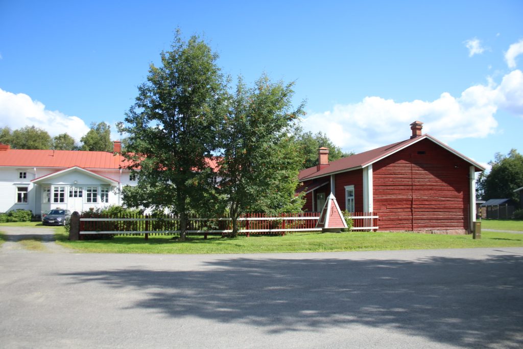 Platz mit Baum und rote Hauser im Hintergrund