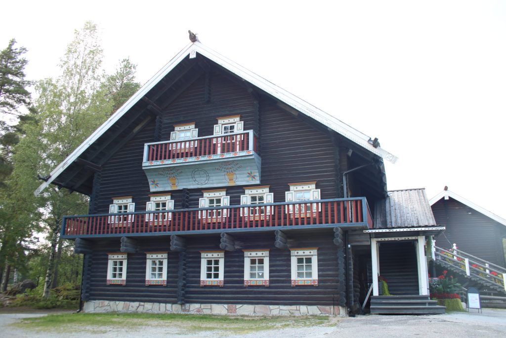 Dunkles Holzhaus mit bunten Fensterrahmen