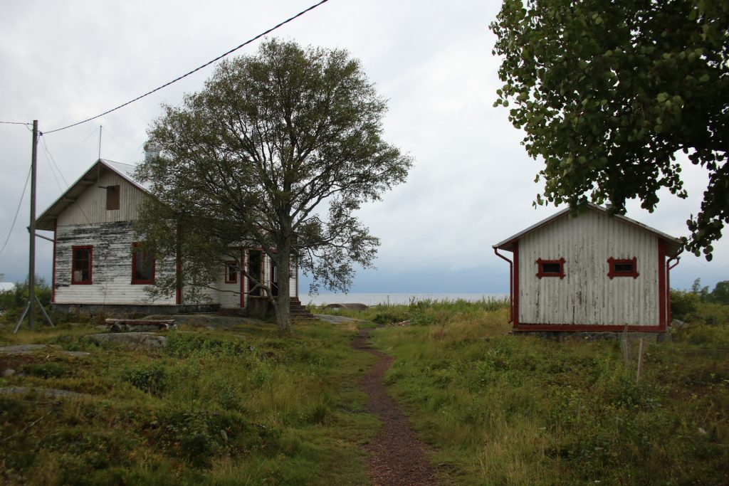 Hütte hinter Baum links und rechts kleine weiße Hütte