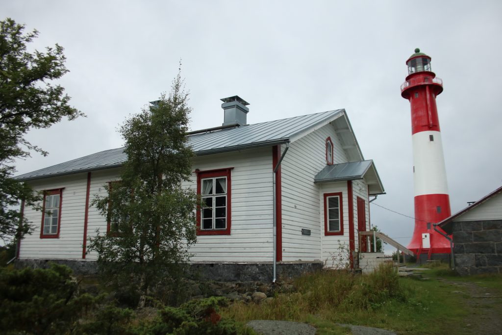 Weißes Holzhaus mit roten Fensterrahmen