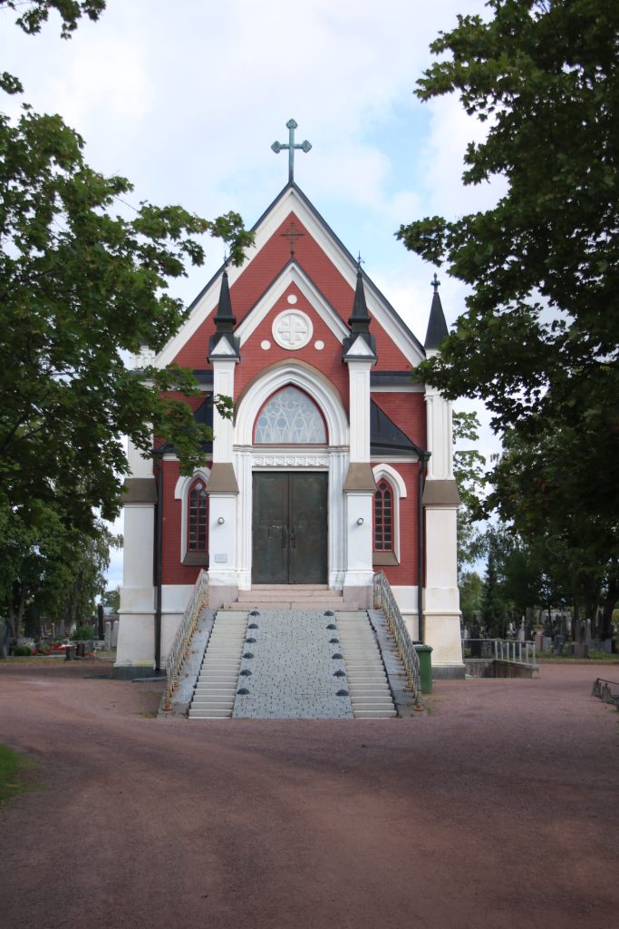 Rot-weiße Kapelle umrandet von Bäumen