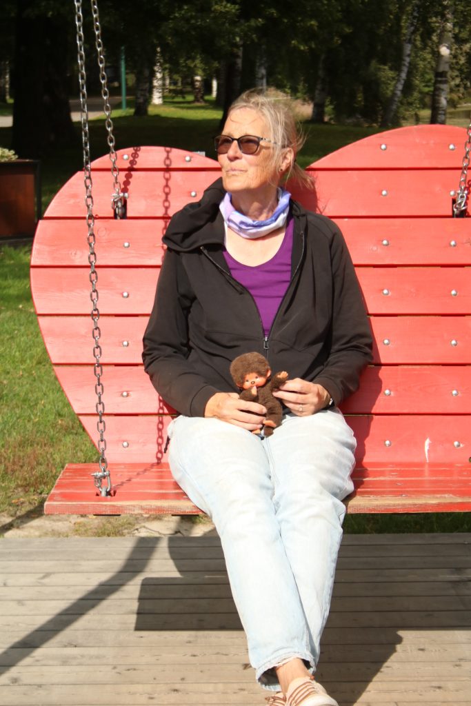 Frau im schwarzen Hoodie auf einer roten Herzschaukel