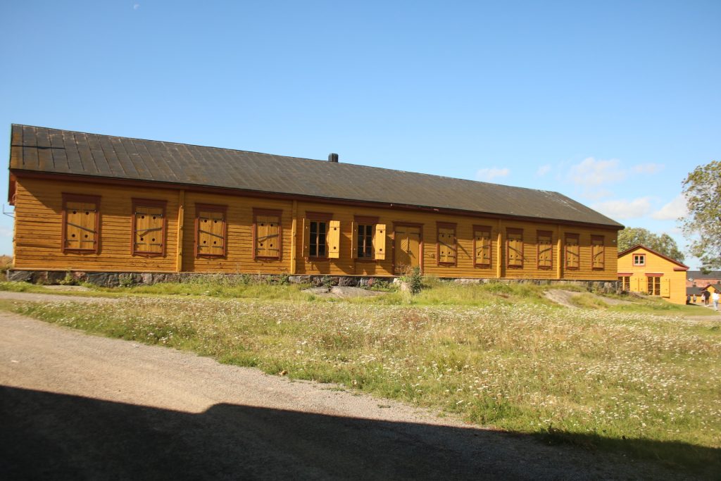 gelbes Haus davor Wiese