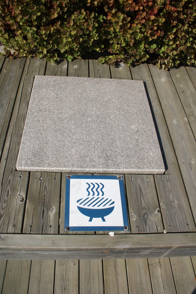 Stein in Hlozfläche und Grillzeichen