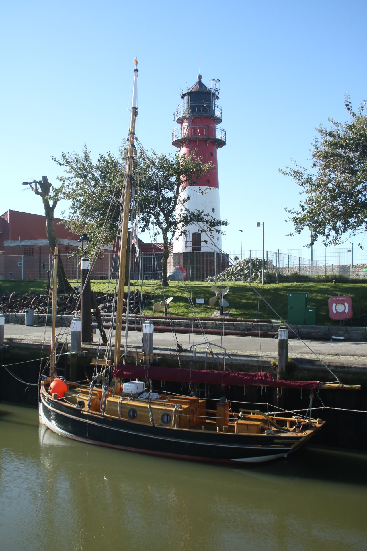 Segelschiff mit Leuchtturm im Hintergrund