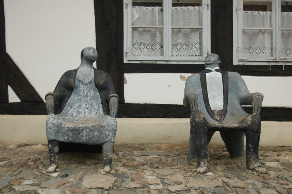 Zwei Steinsitze in Form von Figuren