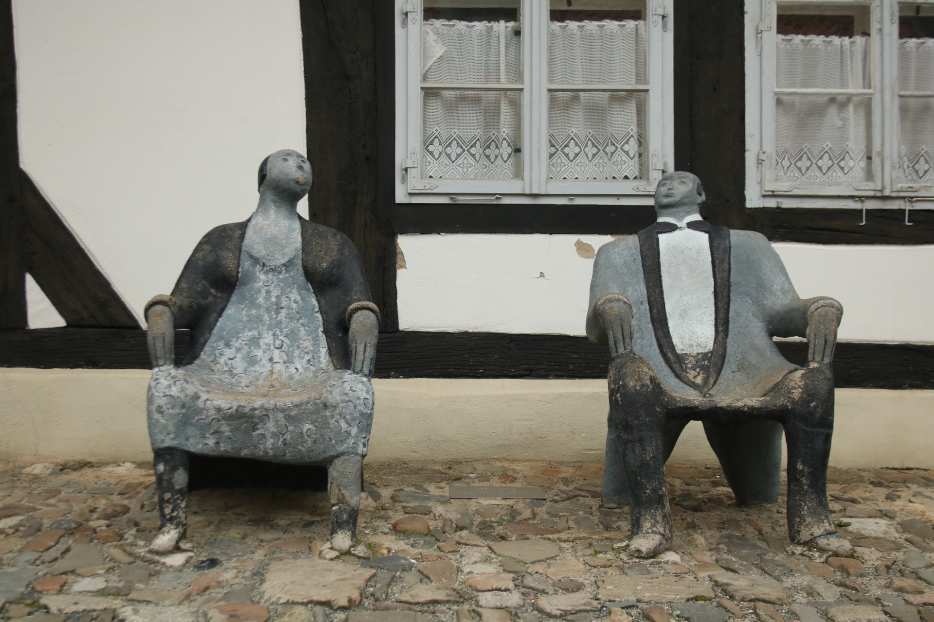 Zwei Steinsitze in Form von Figuren